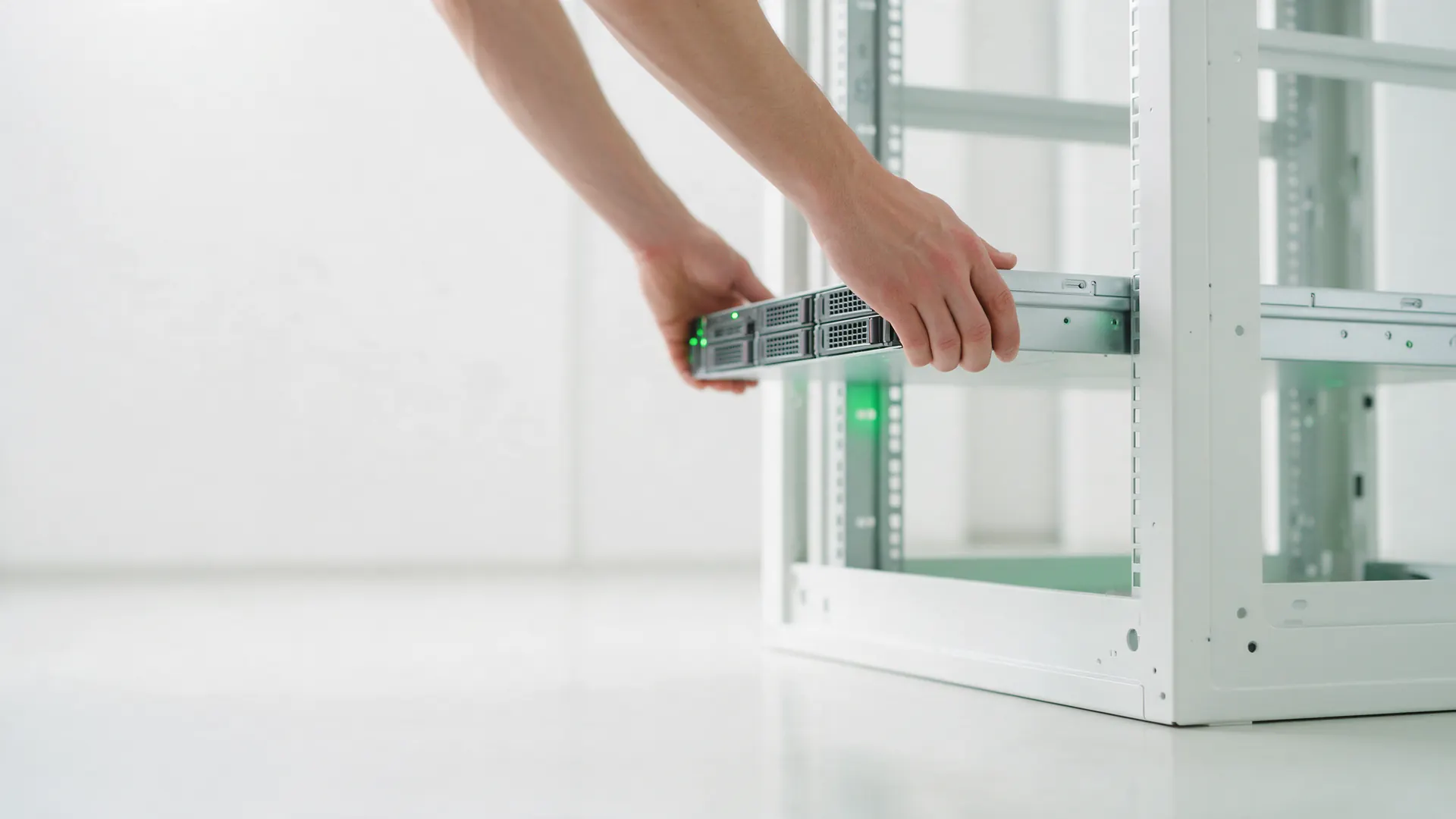 Técnico encaixando um servidor no rack de um datacenter claro